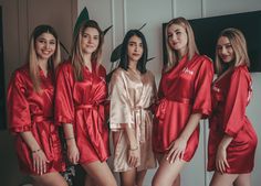 four women in red robes standing next to each other with their hands on their hips