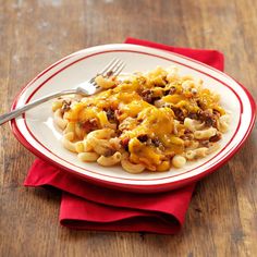 a white plate topped with macaroni and cheese on top of a wooden table