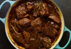 a pot filled with meat and sauce on top of a table