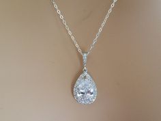 Wedding Bridal Clear Cubic Zirconia Teardrop Halo Silver Pendant Necklace with .925 Sterling Silver Chain. CHAIN is 18 inches (45.7 cm) long. PENDANT is 1 inch (2.5cm) long including bail. Elegant and stunning, this necklace is perfect for weddings or special occasions such as birthdays, anniversaries, graduations, proms...or whatever you can imagine! This necklace has .925 Sterling Silver 18 inches cable chain, Rhodium Plated cz pear shaped component, and Rhodium Plated cz bail. NECKLACE will b Dazzling White Bridal Necklace For Wedding, Dazzling White Bridal Necklace, Brilliant Cut Drop Wedding Jewelry, Pear-shaped Brilliant Cut Wedding Necklaces, Wedding Jewelry With Diamond Accents Teardrop Pendant, Wedding Teardrop Pendant Jewelry With Diamond Accents, Teardrop Pendant Jewelry With Diamond Accents For Weddings, Wedding Teardrop Pendant Necklace With Diamond Cut, Teardrop Brilliant Cut Wedding Necklaces