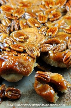 some pecans sitting on top of a piece of bread covered in caramel sauce