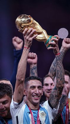 the soccer player is holding up his trophy