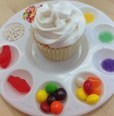 a cupcake with white frosting and candy on it