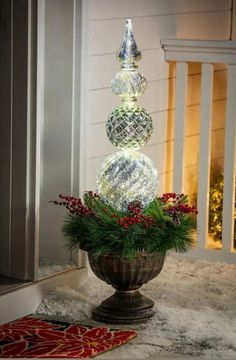 three glass balls are sitting on top of a potted plant in front of a door