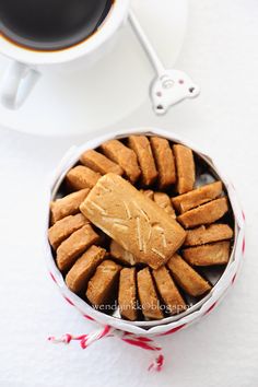 some cookies are in a bowl next to a cup of coffee