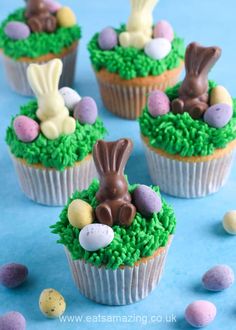 some cupcakes with green frosting and chocolate bunny ears on top are shown