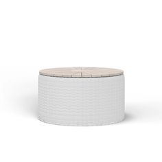 a white round ottoman with an upholstered cushion on the top and bottom side