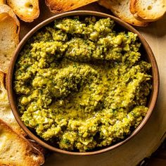 a wooden bowl filled with pesto and bread