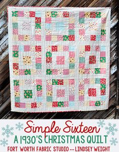 a quilted christmas quilt hanging on a wooden fence with snowflakes around it