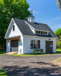 a small white building with a black roof