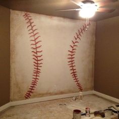 a baseball themed room with paint on the floor and two baseballs painted on the wall