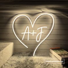 a heart shaped neon sign sitting on top of a white rug next to a box