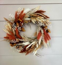 a wreath made out of feathers and flowers on a white wooden background with text overlay that reads diy fall wreath