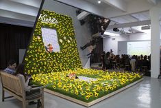 people are sitting in chairs around a fake flower display that looks like it has been cut out