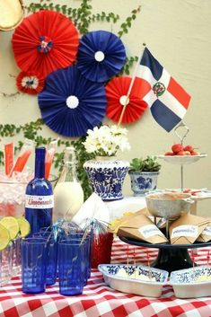 a table topped with plates and cups filled with food next to an american flag decoration