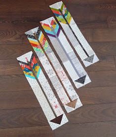 four skis laying on top of a wooden floor next to each other with different designs