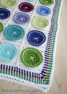 a crocheted blanket with many different colored circles on it