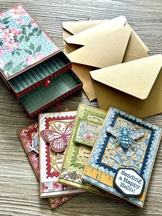 several cards and envelopes sitting on top of a wooden table next to each other