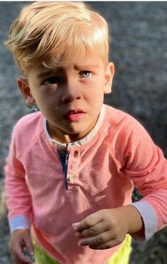 a little boy making a funny face with his tongue sticking out and looking at the camera