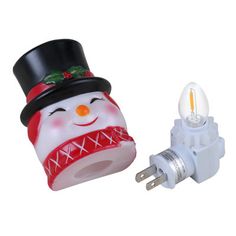 a christmas light with a snowman on it and an outlet plugged into the wall