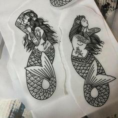 two stickers with mermaids on them sitting on top of a piece of paper