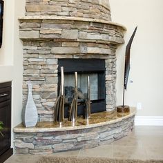 a living room with a stone fireplace and flat screen tv mounted on the wall above it