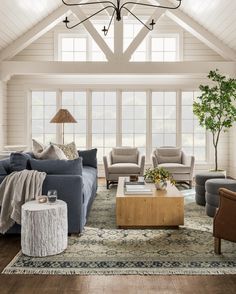 a living room with couches, chairs and a coffee table in front of a large window