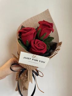 a hand holding a bouquet of red roses