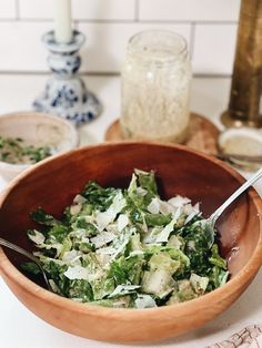 a wooden bowl filled with salad on top of a table