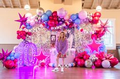 a girl standing in front of balloons and decorations