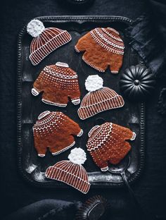 ginger cookies decorated with knitted hats on a tray