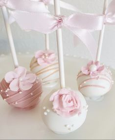 three cake pops with pink flowers on them