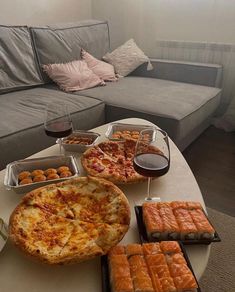 a living room filled with lots of food on top of a white table next to a couch