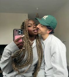 a man and woman are kissing while taking a selfie