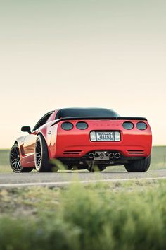 a red sports car is parked on the road