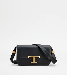 With an essential design, this micro flap bag is characterized by a pressure T Timeless buckle. Crafted in refined calfskin leather, it comes with a practical front pocket concealed by the flap. The shoulder strap is adjustable by branded metal sliders, while a saddlery-style stitching peaks at the sides in the distinctive T-stitching. A unisex model that fully combines traditional craftsmanship and contemporary elegance. Luxury Tan Flap Bag With Removable Pouch, Classic Tan Calf Leather Shoulder Bag, Formal Tan Flap Shoulder Bag, Modern Tan Flap Bag With Gold-tone Hardware, Classic Tan Leather Flap Bag, Classic Tan Flap Bag With Detachable Strap, Classic Tan Bags With Magnetic Closure, Classic Tan Flap Bag For Office, Timeless Tan Shoulder Bag For Evening