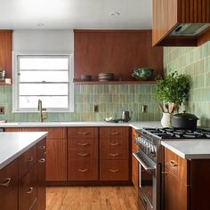 a kitchen with wooden cabinets and white counter tops, along with a stove top oven