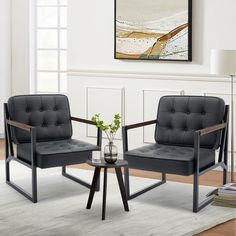 two black chairs sitting next to each other on top of a white rug in a living room