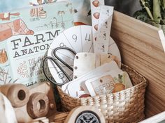 a basket filled with lots of different types of items next to a book and plant