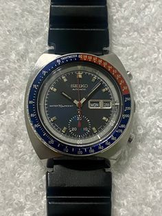 VINTAGE, SEIKO 6139-6005, PEPSI, CHRONOGRAPH, DAY DATE, ONE REGISTERS, STAINLESS STEEL, JAPAN MADE WATCH FULLY SERVICED. This is a fine, Japan made wristwatch. The movement is mechanical and stamped SEIKO SEVENTEEN 17 JEWELS 6139. I just got the full service done one the watch, it was cleaned, oiled and timed a 200 dollar's value. It is in working condition, it is keeping time. I tested it and it is working like it should. The dial is original, factory dial, color and condition are as pictured. Vintage Black Chronograph Watch With Subdials, Retro Black Chronometer Watch Accessories, Retro Black Watch Accessories With Chronometer, Retro Black Watch With Tachymeter, Black Retro Watch With Tachymeter, Collectible Analog Chronograph Watch With Round Dial, Collectible Analog Chronograph Watch, Collectible Black Watch With Subdials, Black Collectible Watches With Subdials