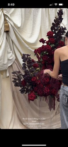 a woman standing in front of a flower arrangement