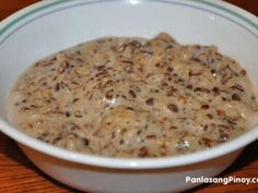 a white bowl filled with oatmeal on top of a wooden table