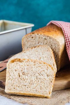 a loaf of bread sitting on top of a wooden cutting board next to a container