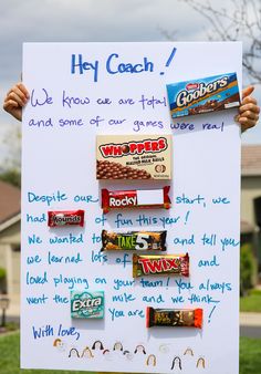 a person holding up a sign with candy on it