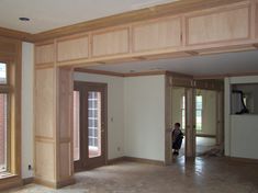 an empty living room with unfinished wood paneling and doors on both sides of the room