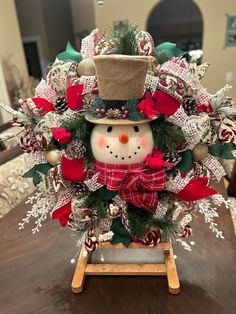 a snowman wreath on top of a wooden table