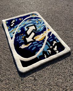 a blue and white rug sitting on top of a cement floor next to a parking meter