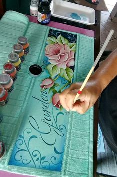 a person is painting flowers on a table