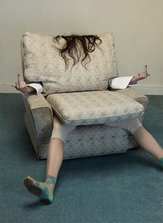 a woman laying on the floor in front of a chair with her legs spread out