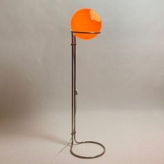 an orange floor lamp on a white background